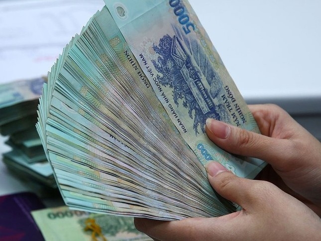 Nhân viên một ngân hàng tư nhân kiểm đếm tiền mặt tại phòng giao dịch ở Hà Nội.